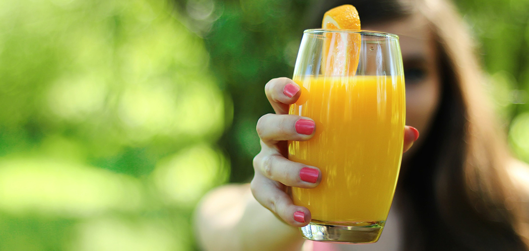 Woman holding glass of juice cleanse