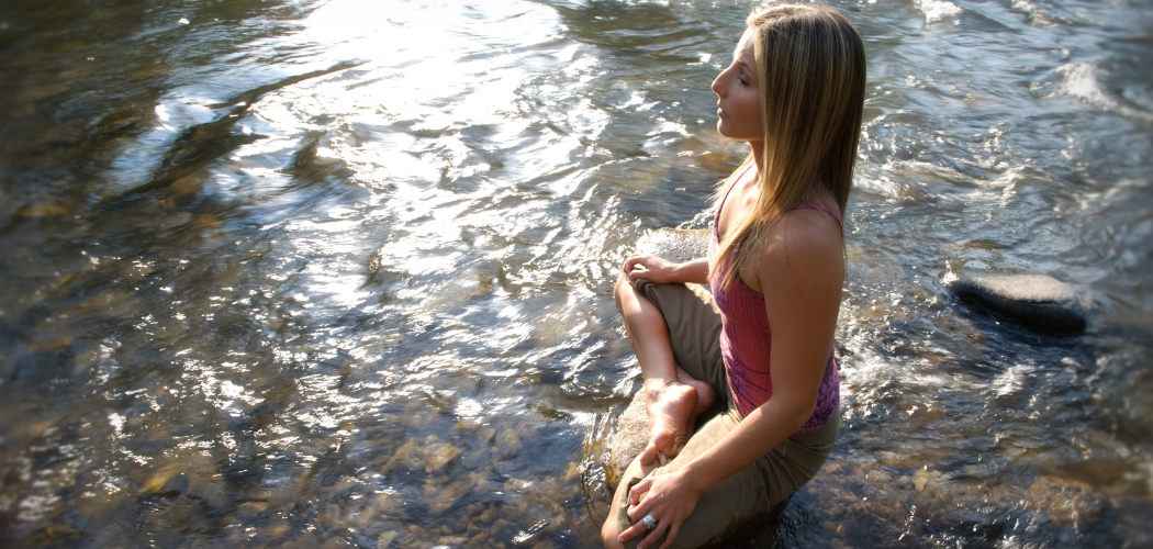 Nealy Fisher thinking about her wish for life in lotus pose over a river