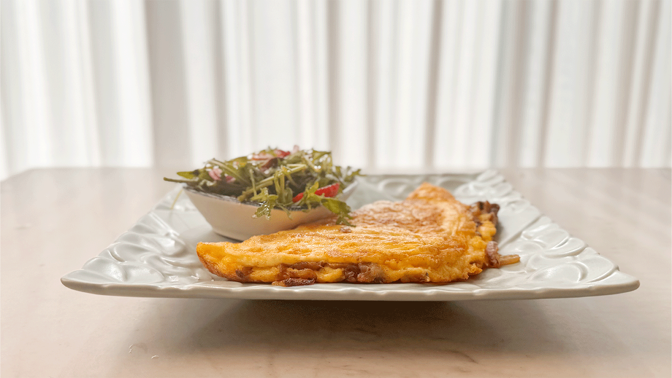 Cheesy mushroom omelet served with a side salad on a white plate – a flexible and easy meal from The Flexible Chef